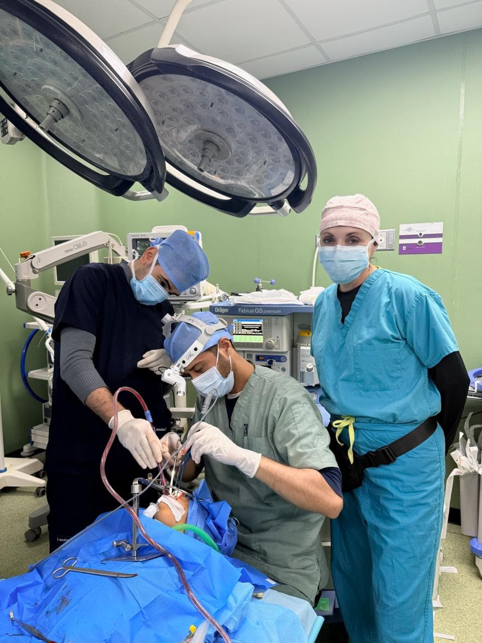 Surgical team operating under theatre lights