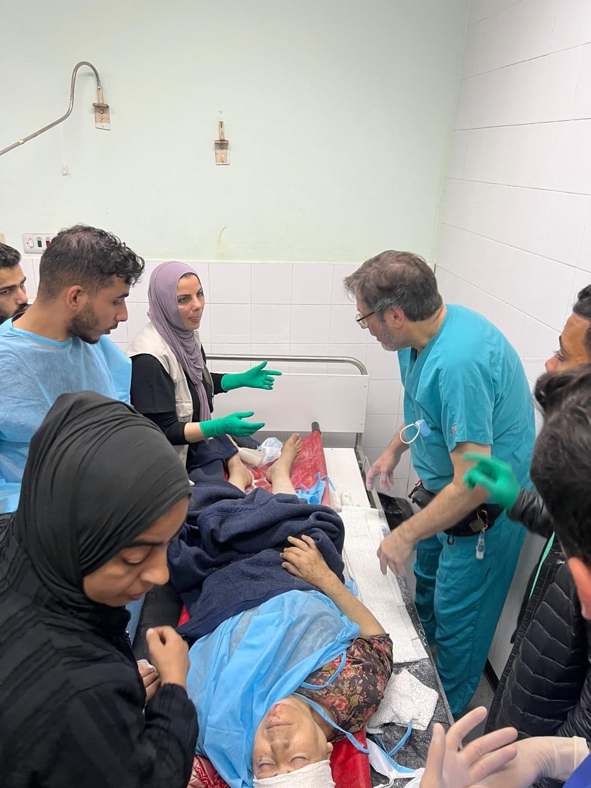 Medical team gathered around a patient's bed