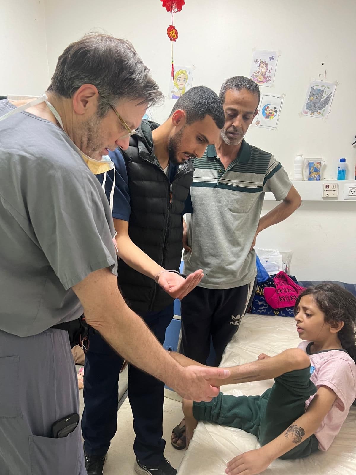 Doctor examining a young girl's arm