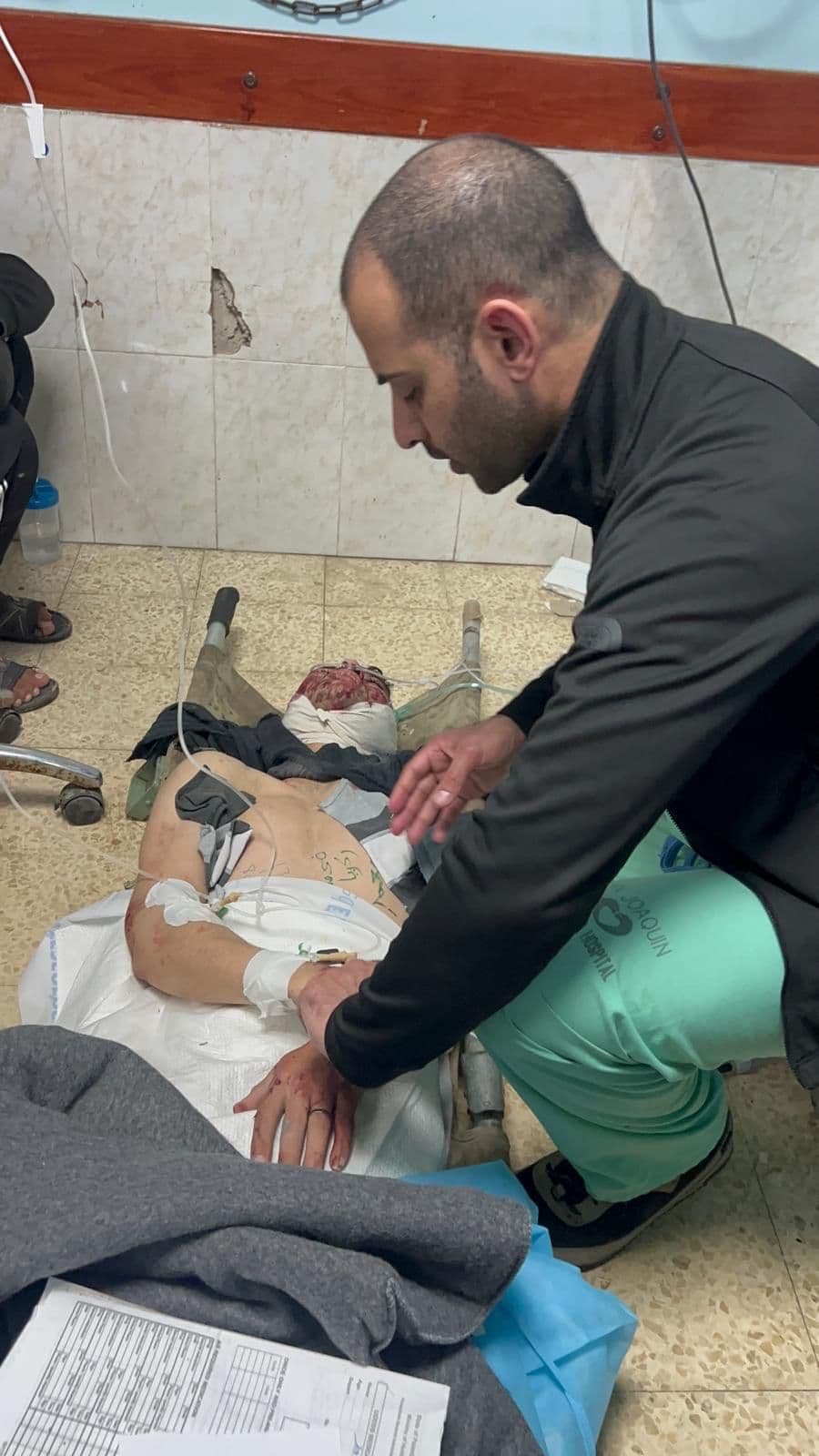 Doctor kneeling to treat a patient on the floor